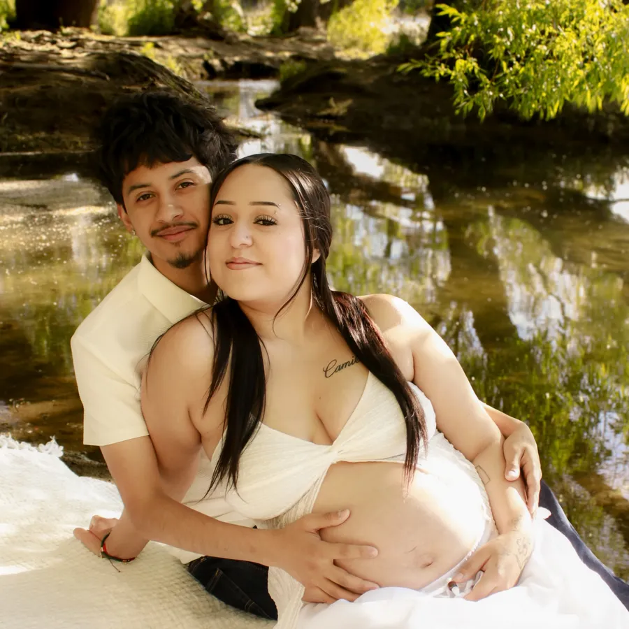 Couple maternity portrait beside a reflecting creek