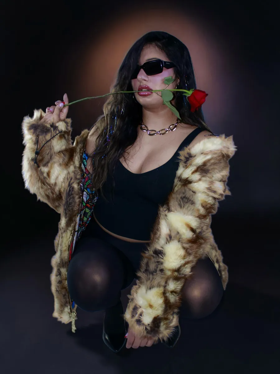 Portrait with a rose in teeth, fur coat, deep red vignette