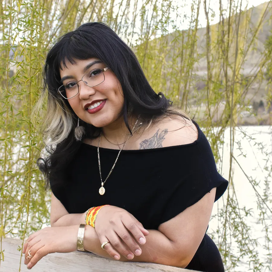 Smiling portrait under willow branches in soft daylight