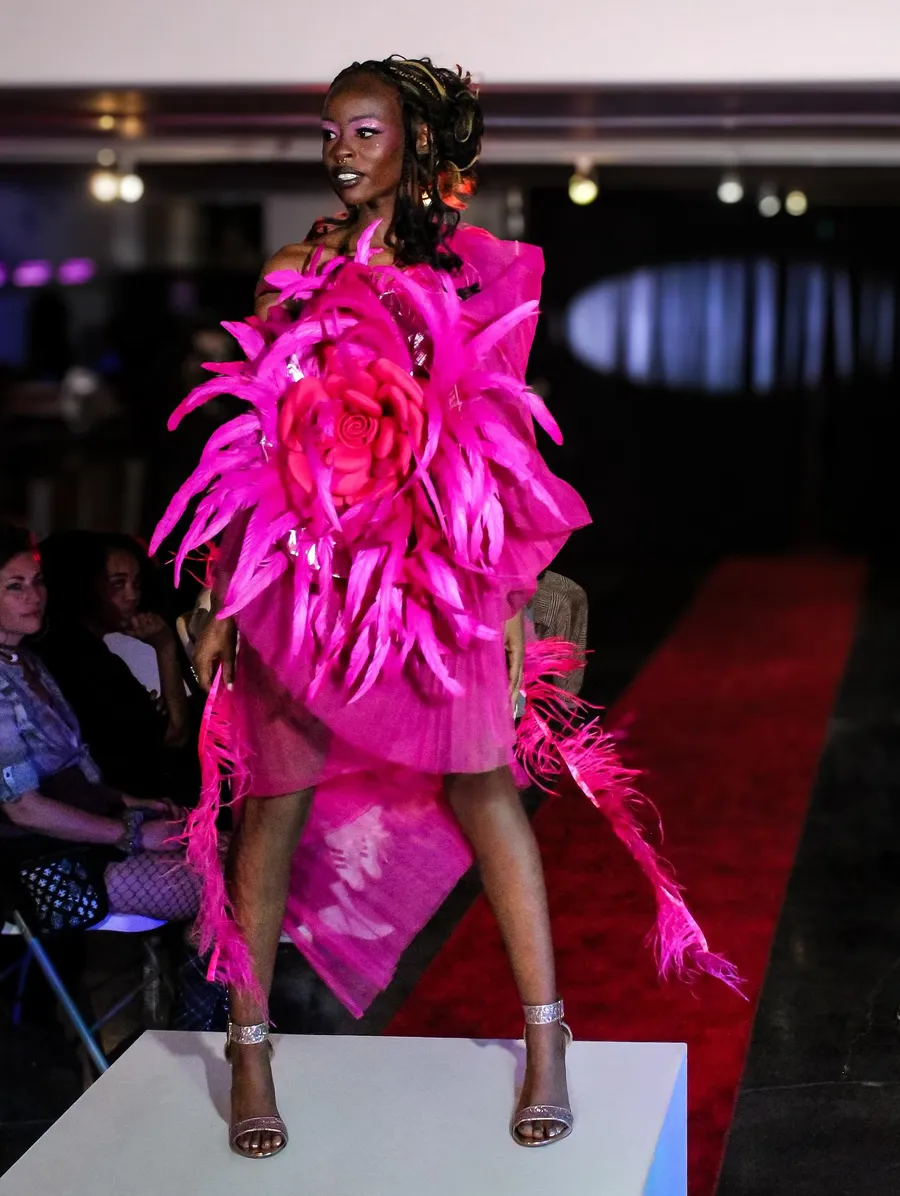 Runway look with a sculptural pink feathered headpiece