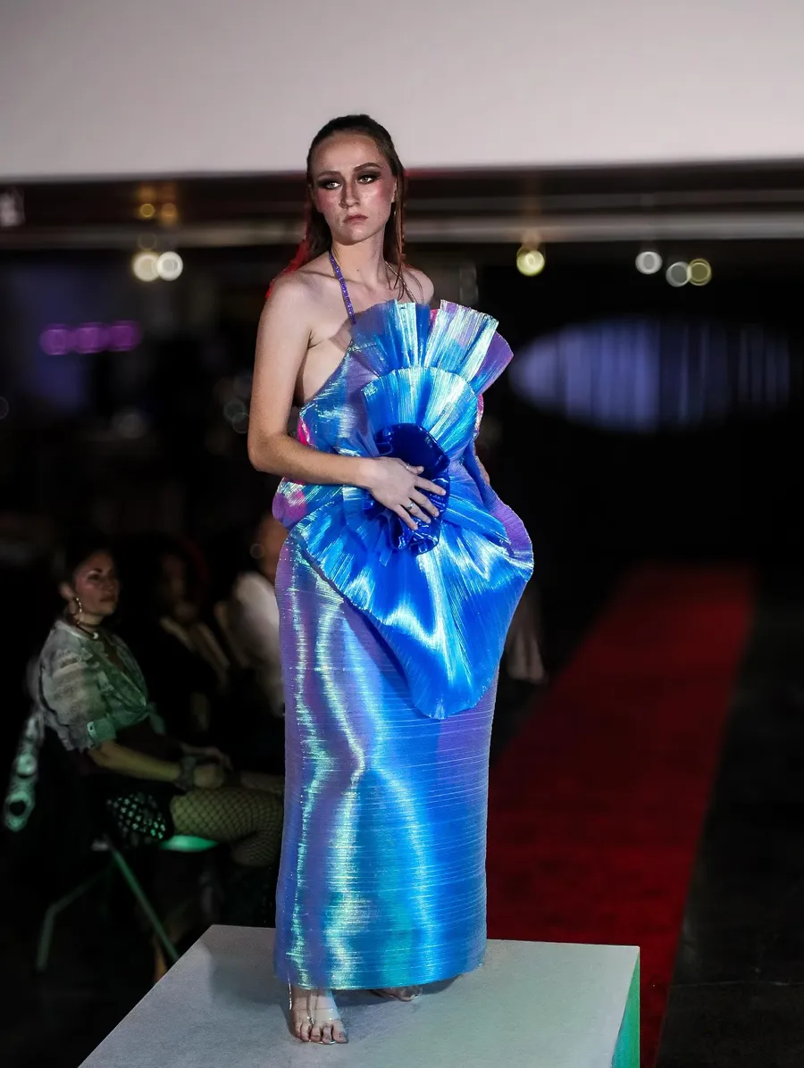 Runway look in an iridescent blue dress