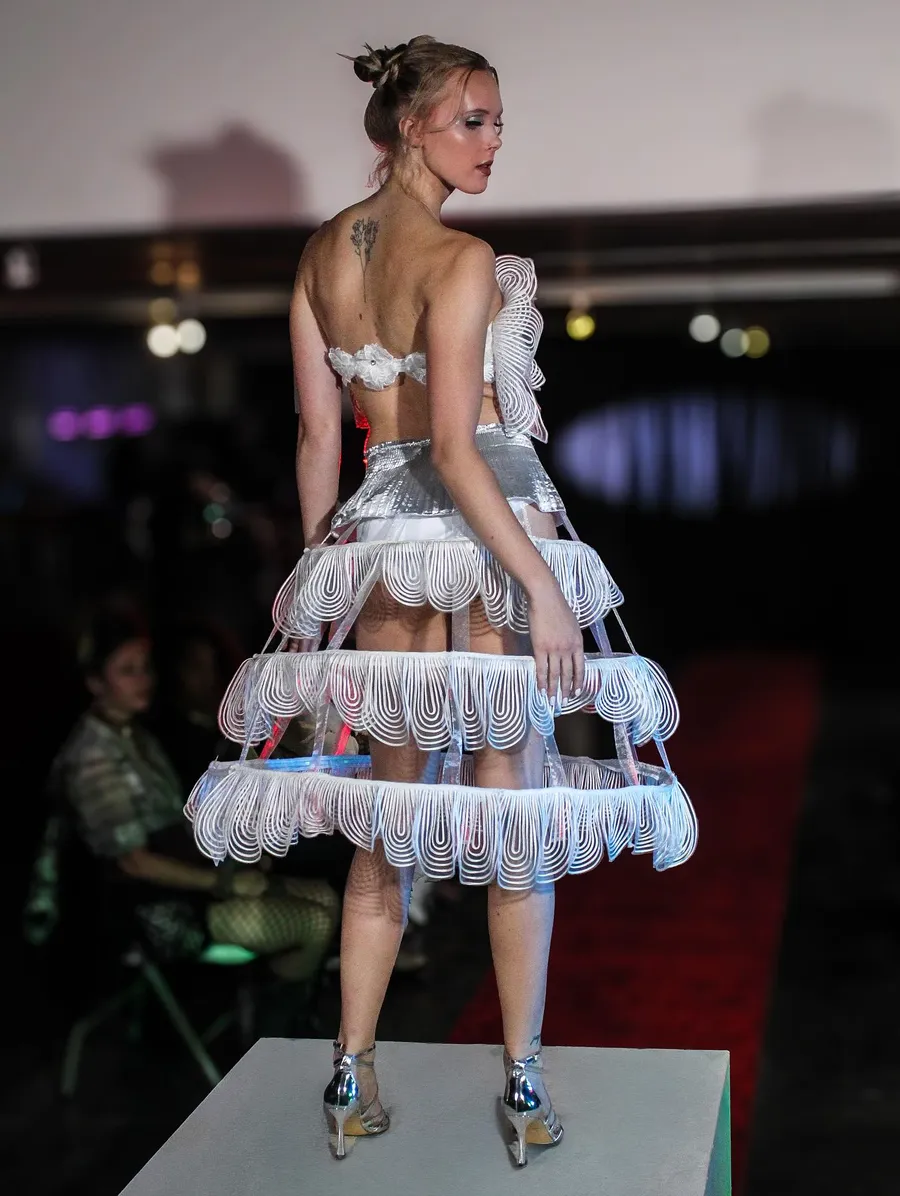 Runway look in a sculptural silver hoop skirt