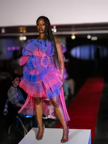 Runway look in a purple and pink ruffled dress
