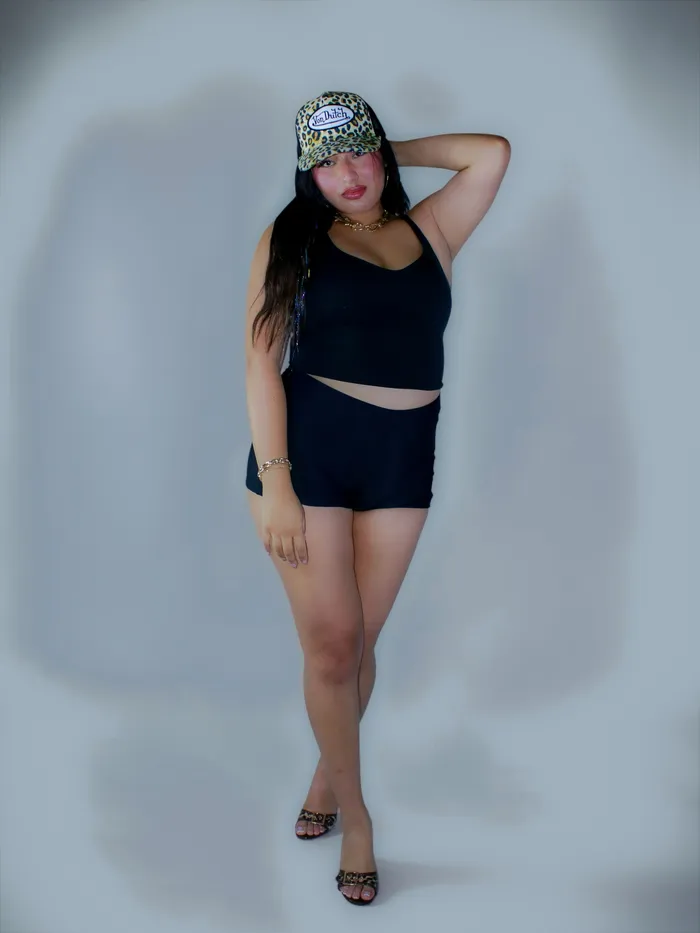 Full-length portrait against a pale blue studio wall