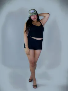 Full-length portrait against a pale blue studio wall
