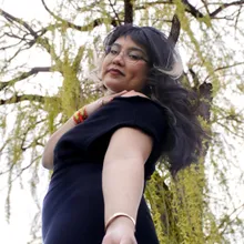 Low-angle smiling portrait under the willow