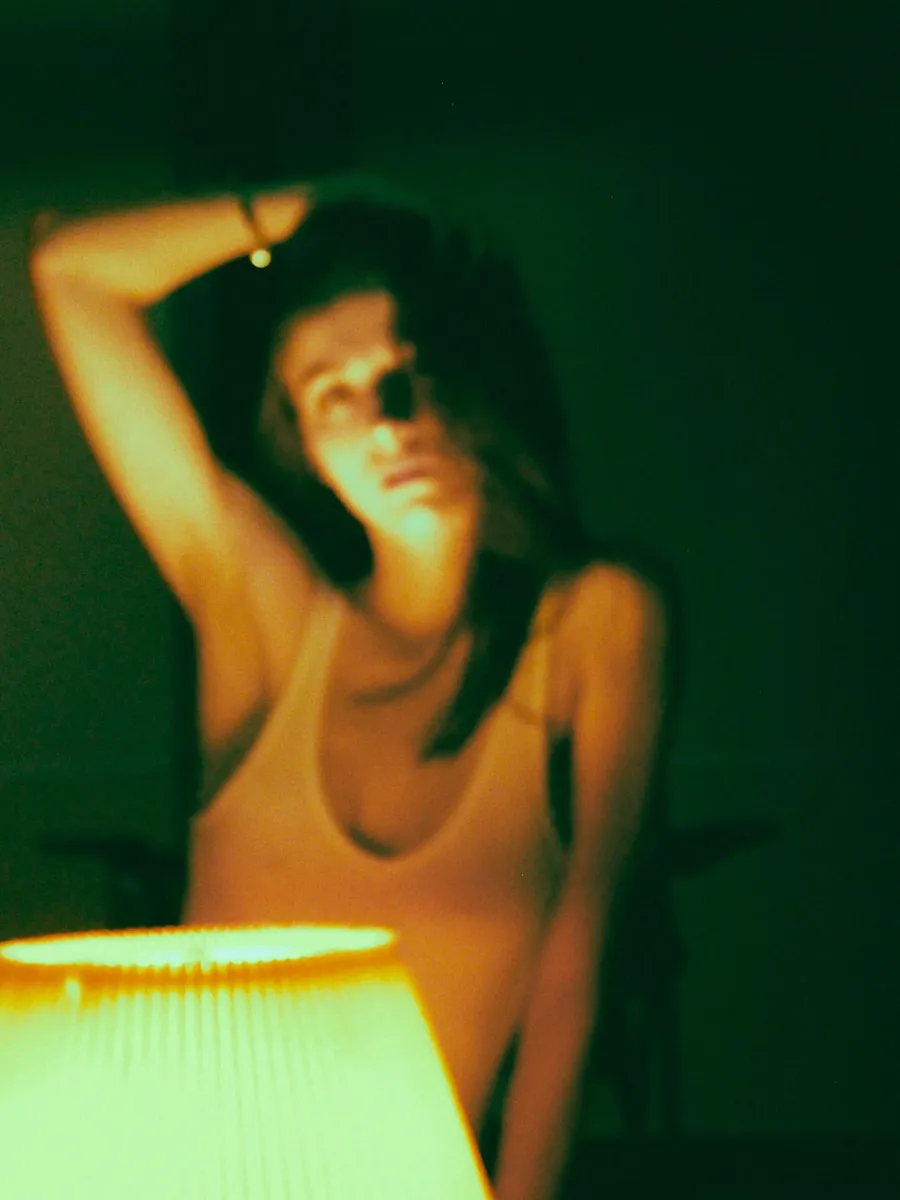 Portrait with arm raised in deep green light
