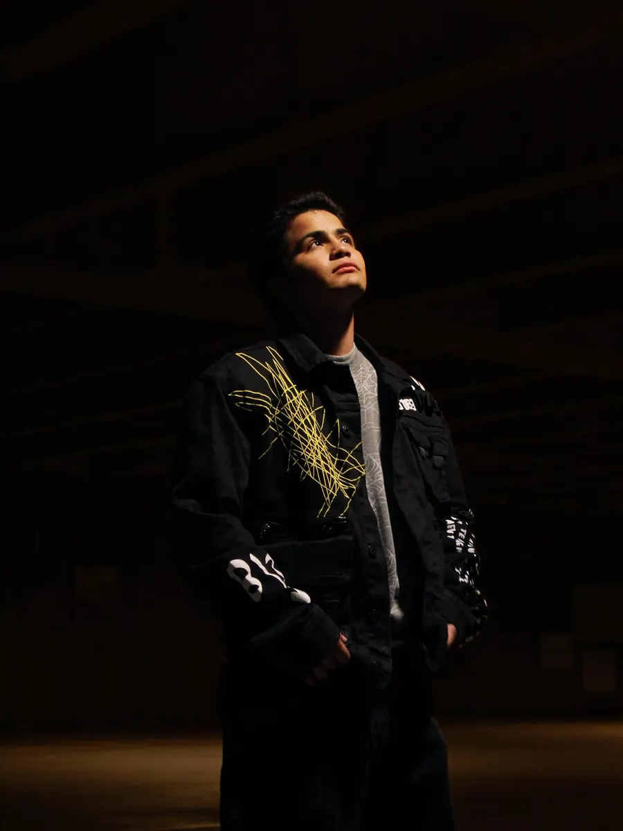 Portrait in a scribble-print jacket looking up in a parking garage