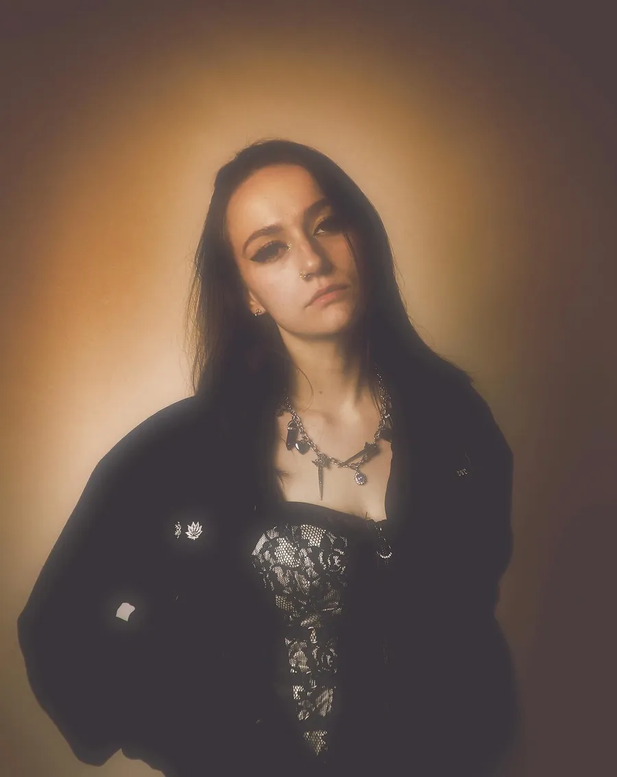 Portrait in a black lace corset, warm-toned studio glow