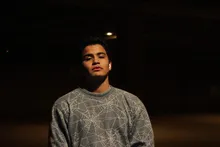 Portrait in a web-print sweater in a parking garage